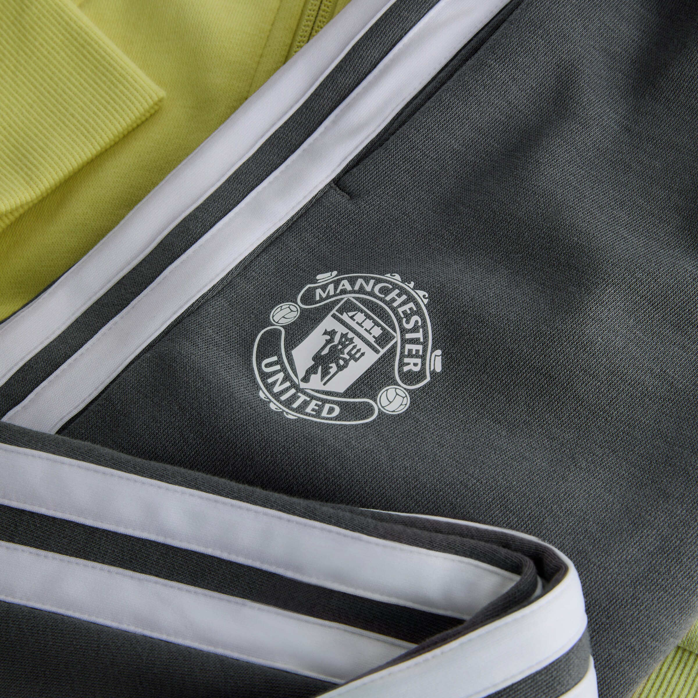 Manchester United x adidas Kids Essentials Tiberio 3-Stripes French Terry Tracksuit Yellow/Grey Jaune Détail [4-4]